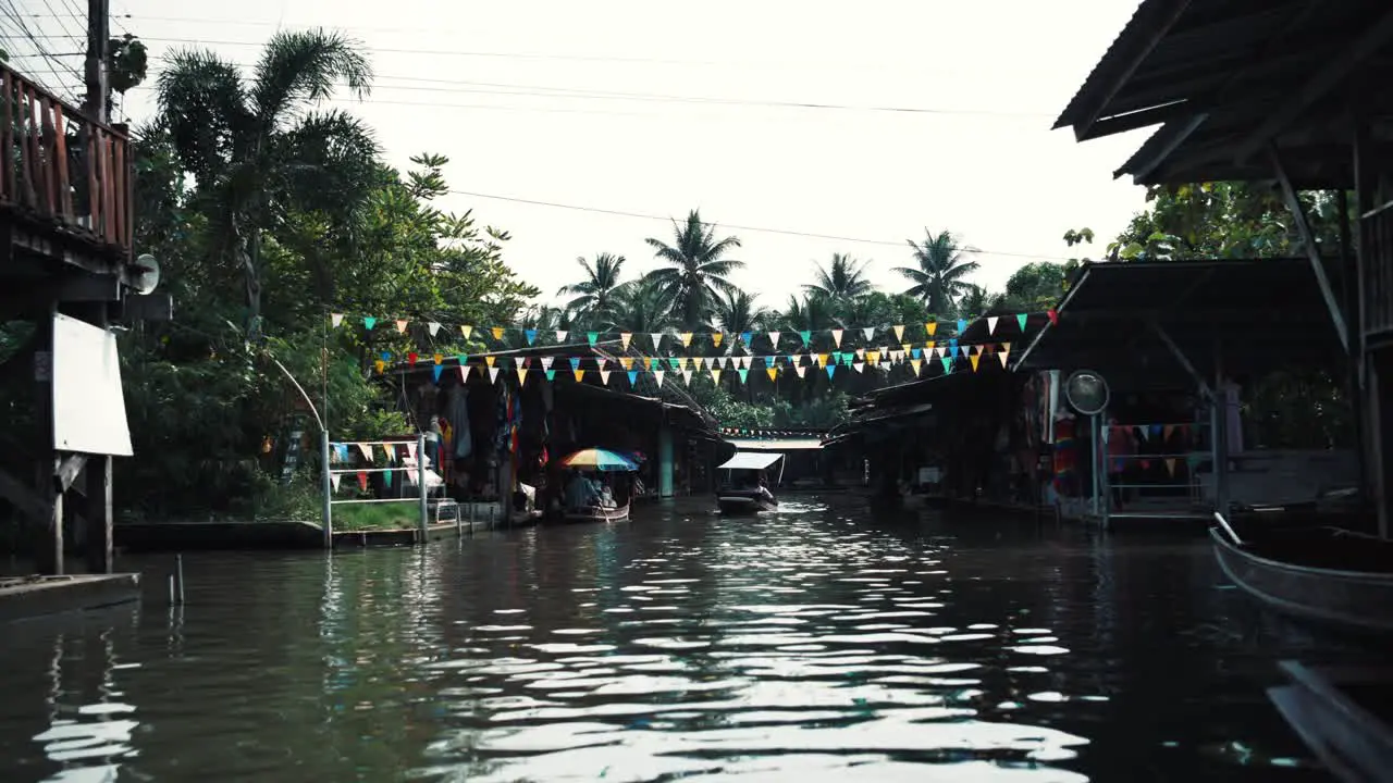 A boat sails through a wide canal in Thailand