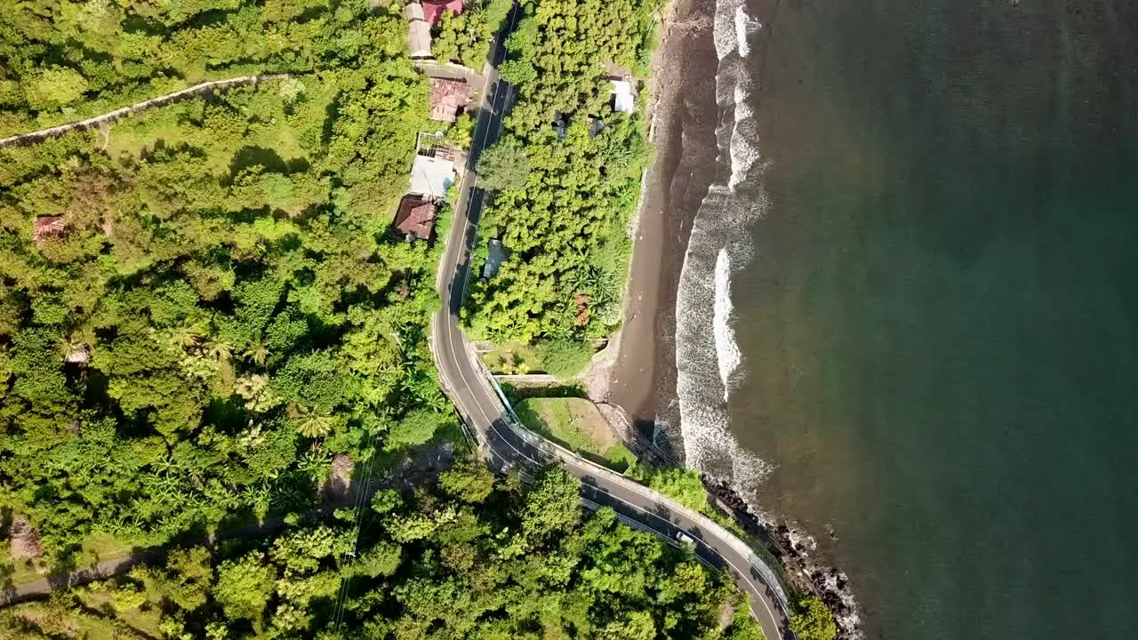 bird eyes view via drone of the highway beside the beach and the waves wash the coast in 4K and 30 fps