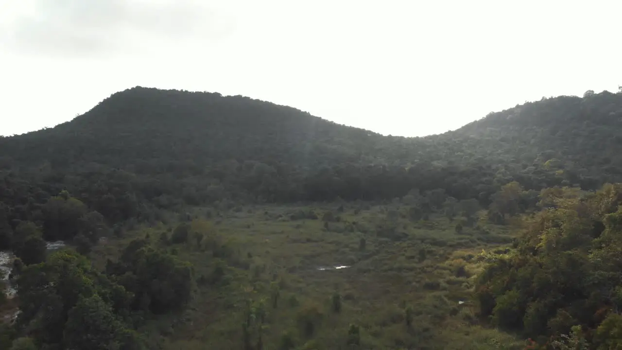 Tropical lush green hill which extends to the horizon in Koh Rong Sanloem Cambodia Aerial Fly over shot