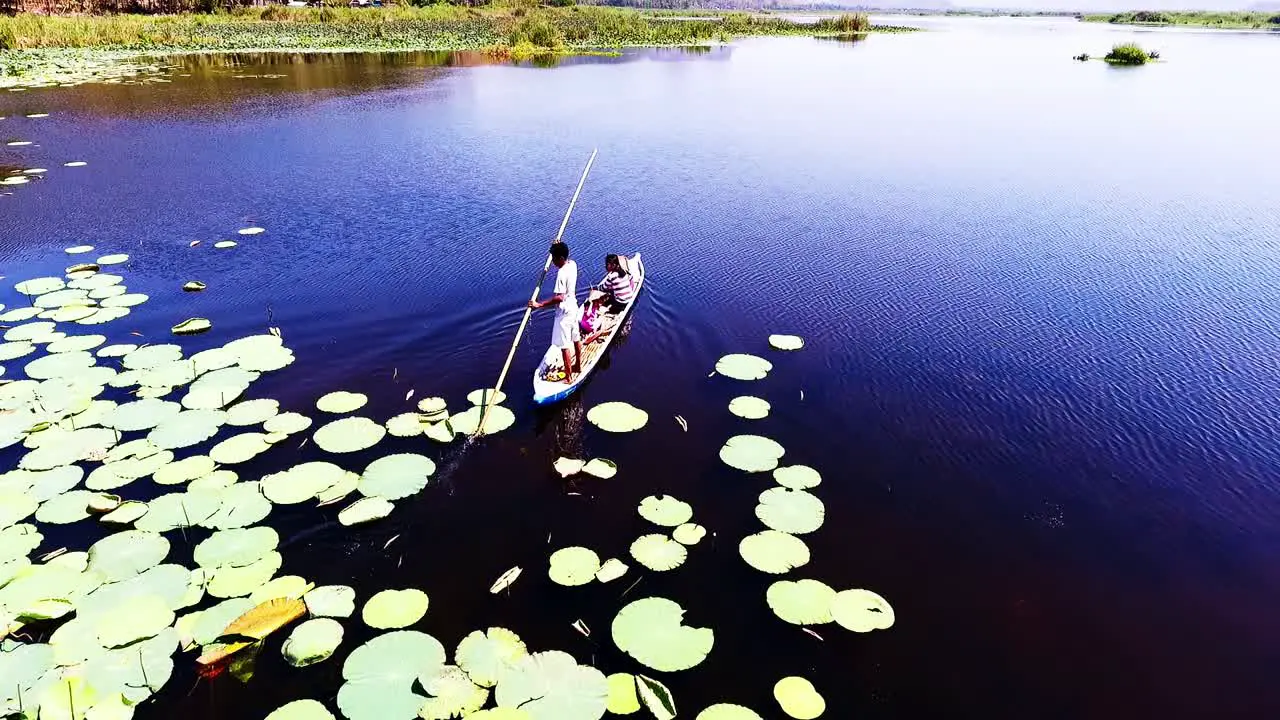 Young man punts his family across Lebo Lake in West Sumbawa Indonesia