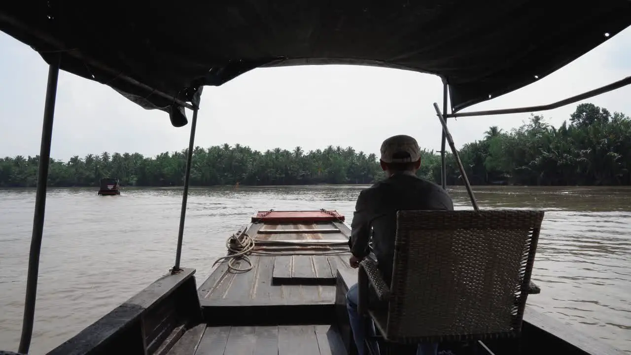 Mekong Delta Vietnam December 10 2022 Boat ride on the Mekong River Saigon Man driving upstream through coconut palms