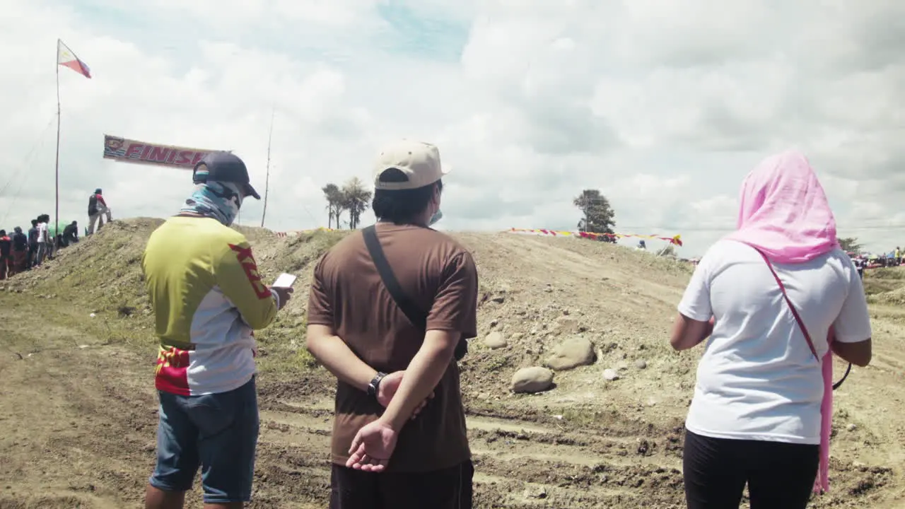 Onlookers watch out for motorcycles at the finish line of the highly anticipated motocross competition in Cadiz City