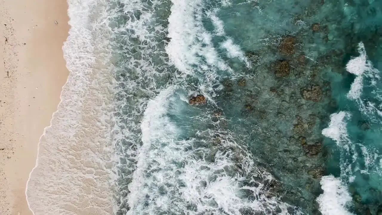 Drone footage of crystal clear blue water and waves on the shore of beach in Cebu Philippines-12