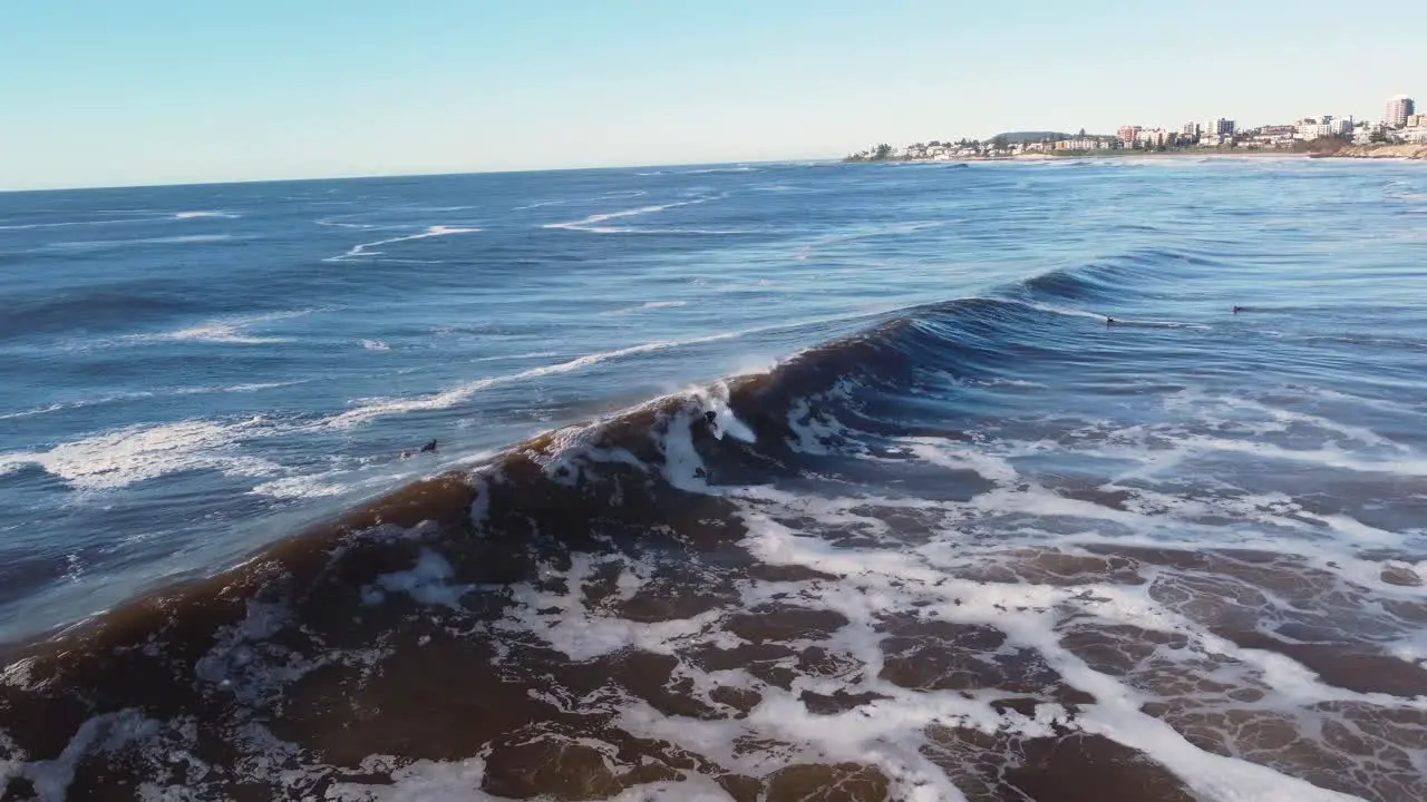 Drone aerial landscape scenic view of surfer riding swell wave barrel surfing extreme sports surfing Central Coast tourism NSW Australia 4K