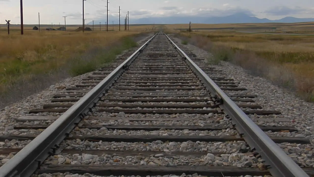 Railroad Tracks Stretch Across A Grassy Plain Into The Horizons