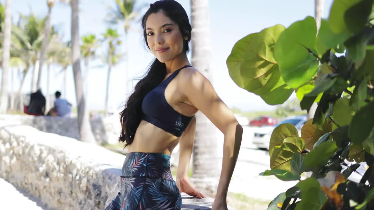 Beautiful sporty woman posing at camera in park