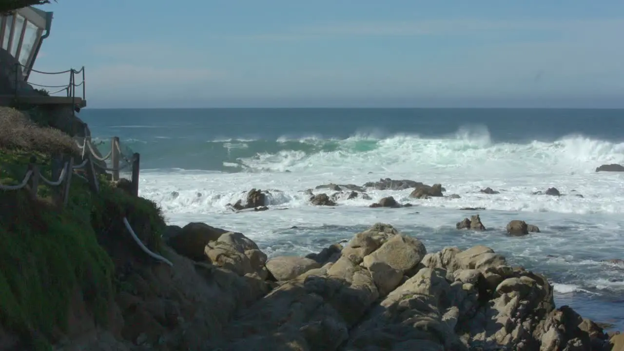 Waves crashing on Carmel Beach with house on