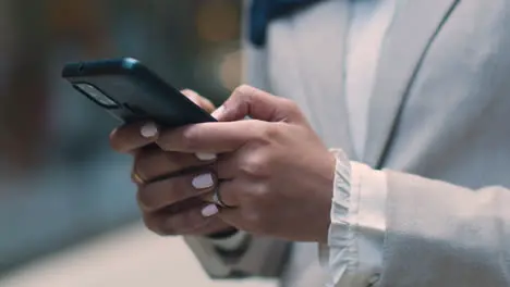 Close Up Of Muslim Businesswoman Checking Messages On Mobile Phone Standing Outside Office In City