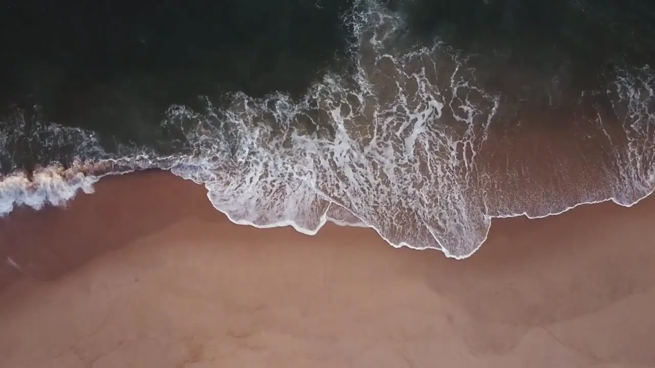 Drone Shot Top View Waves hitting the sand