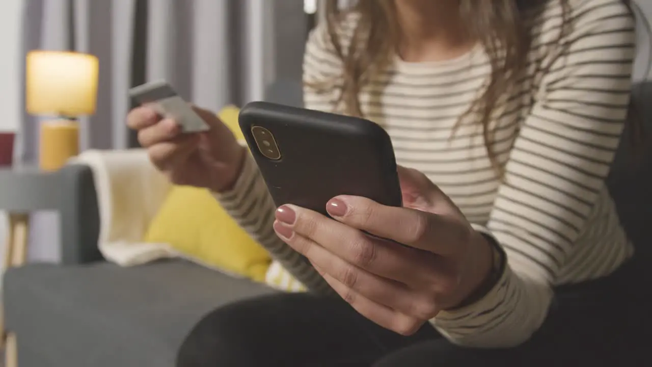 Close Up Of Woman At Home Shopping Online With Credit Card Using Mobile Phone 1