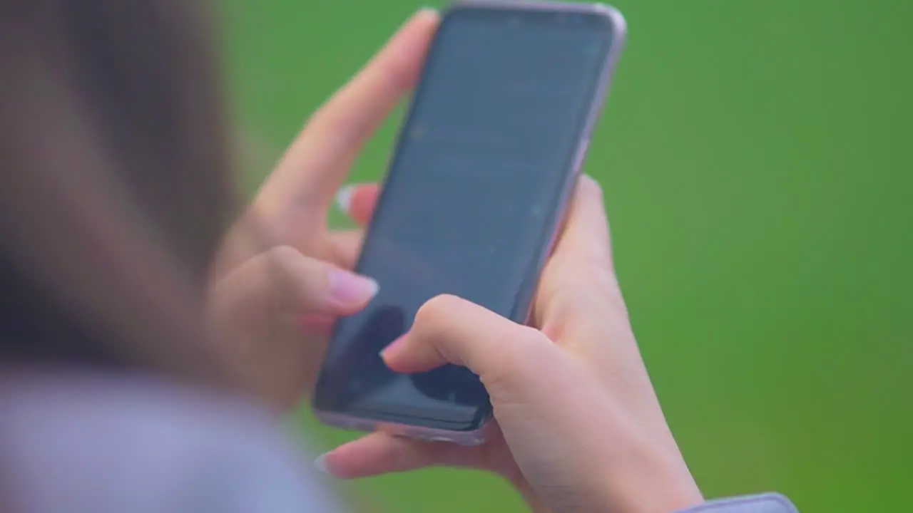 Woman's Hand Typing Message On Cellphone