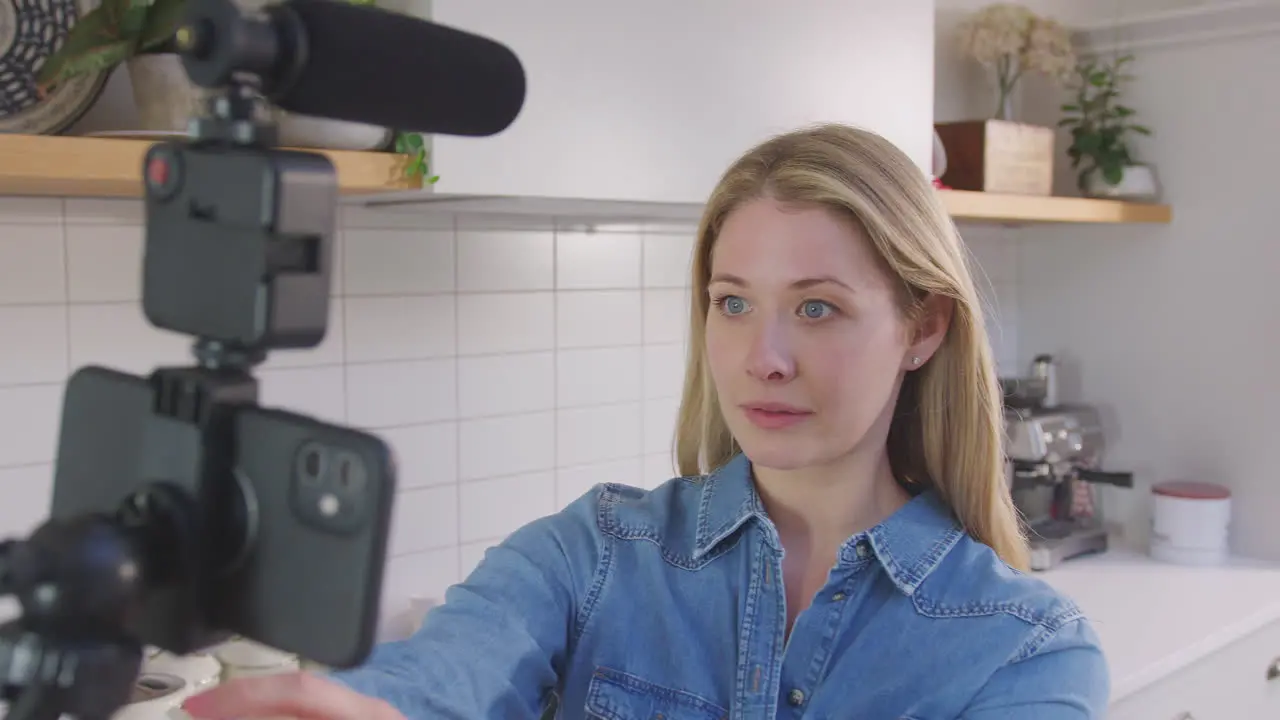 Point of view shot of woman vlogging making social media video as she carries camera around in kitchen at home shot in slow motion