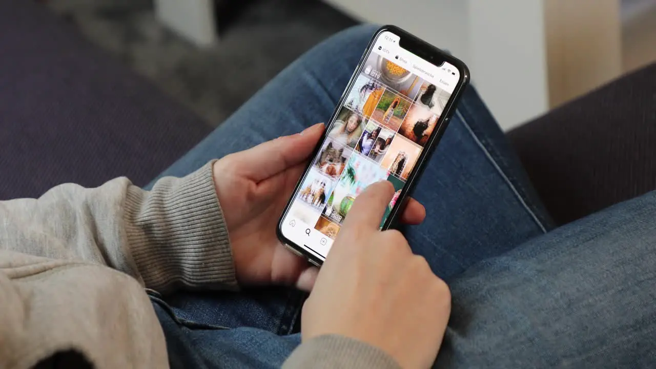 Young woman using Instagram app on an iPhone in casual home environment