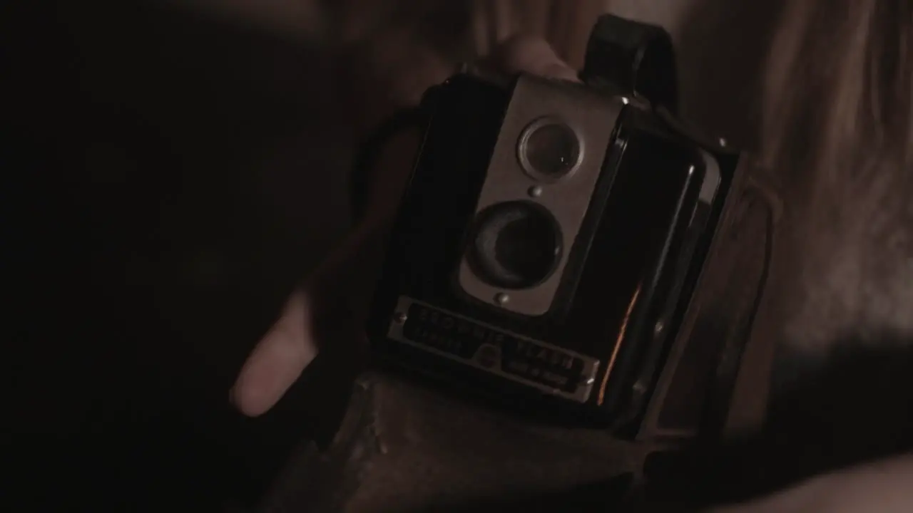 Girl's hands opens Box Brownie leather camera case and reveals to camera