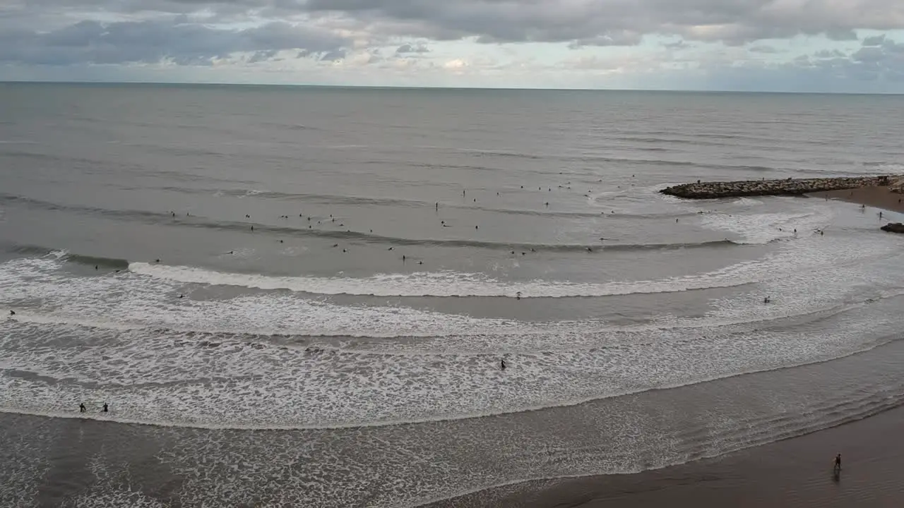 Aerial view of a beach full of surfers from a drone