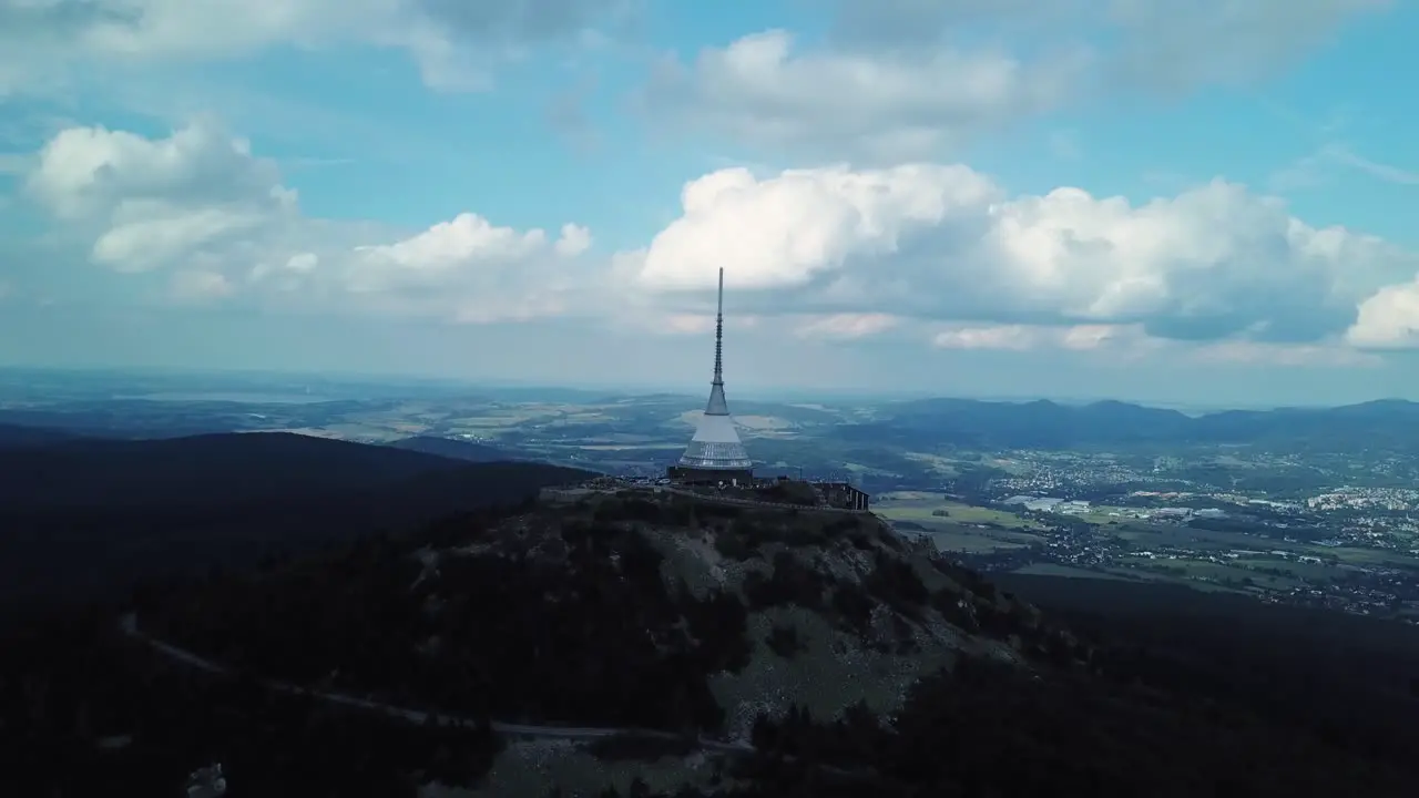 Jested tower during a part clouded day with Liberec town in the distance Drone fly away 4k or UHD 30fps