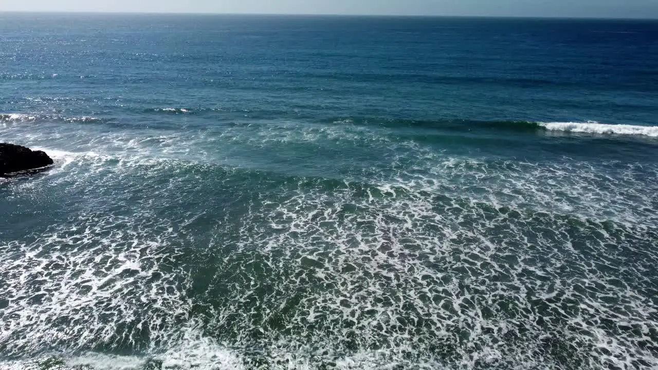 Waves on sandy beach looking out toward the horizon