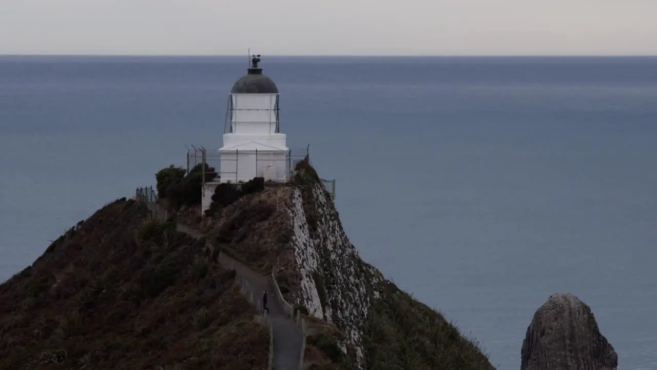 A cloudy day in New Zealand with a light house on the ridge