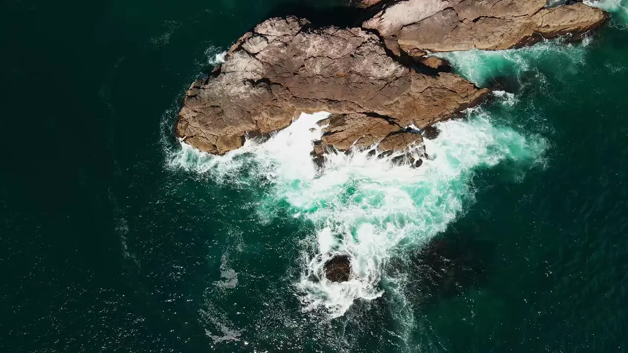 Watching the tide push waves against rocks from above