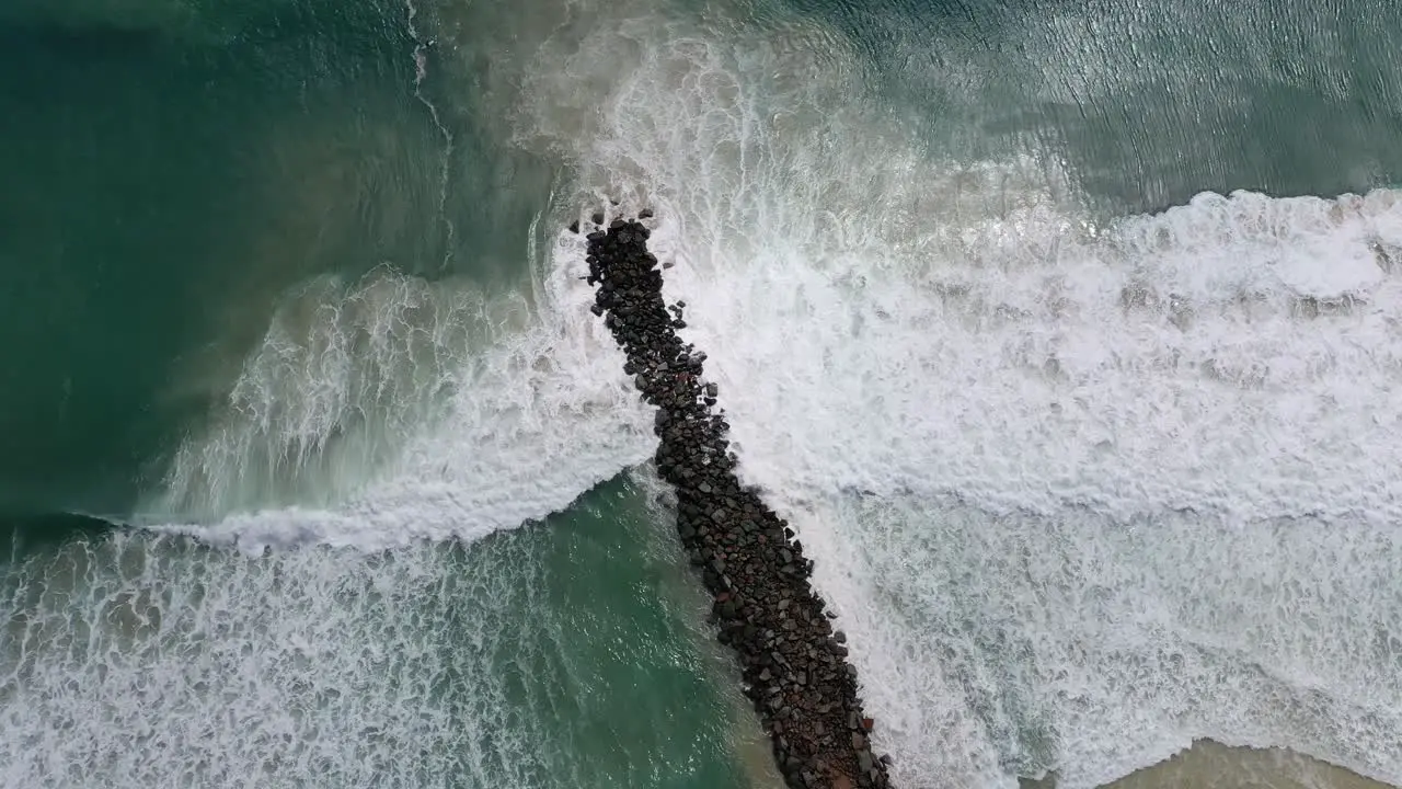 View from above of crashing waves against the Noosa wave breaker