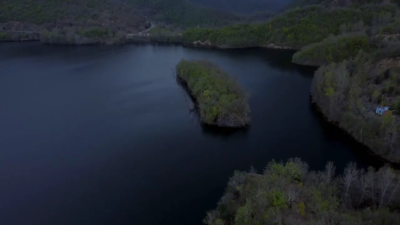 Aerial ascend over island in a lake during a stormy winter day