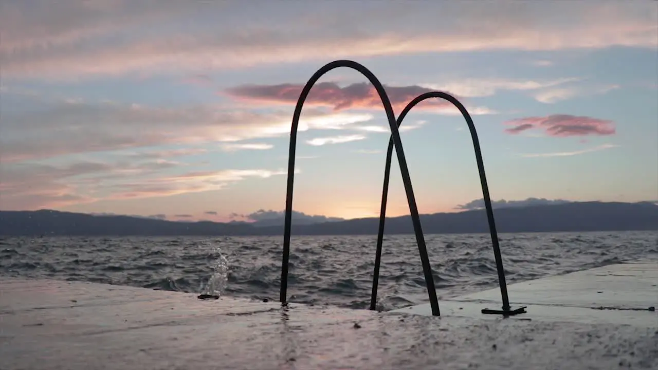 Waves splashing on the pier of a natural lake at sunset with a beautiful golden hour