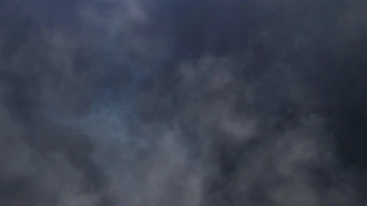 thunderstorm in moving clouds in dark sky