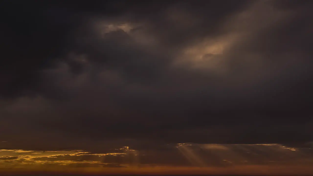 Sunrays Radiating Through Dark Storm Clouds Covering The Sun At Sunset