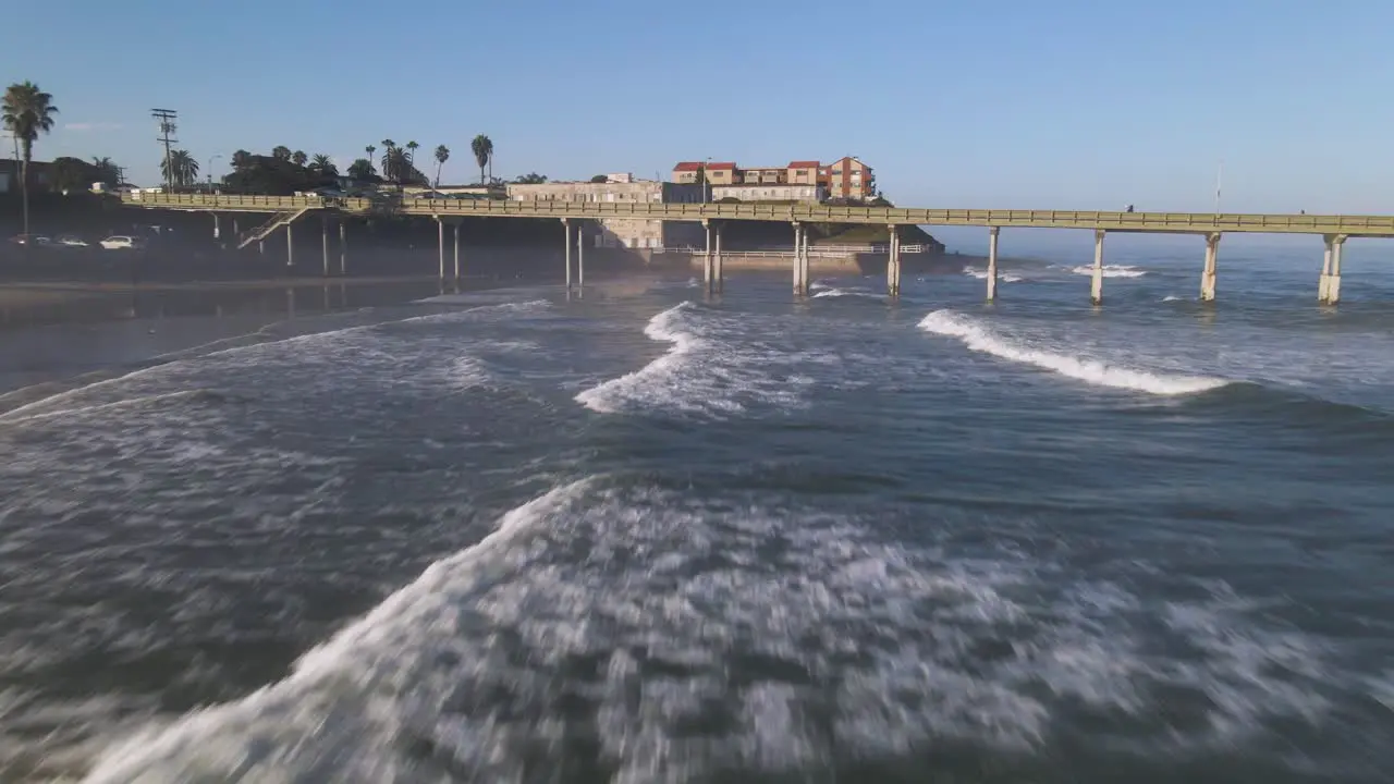 Fast moving drone shot flying low over the waves in San Diego California