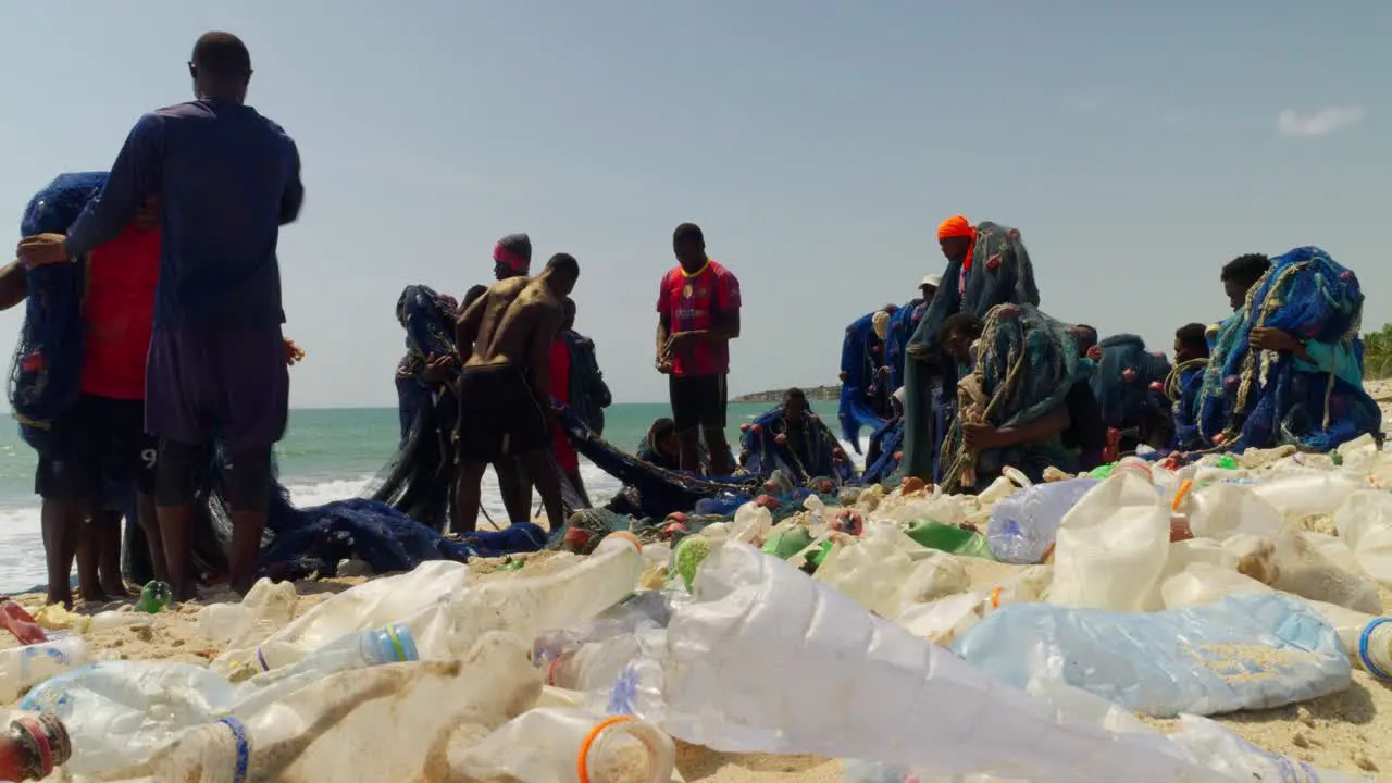 Plastic waste on an African beach with fishermen around