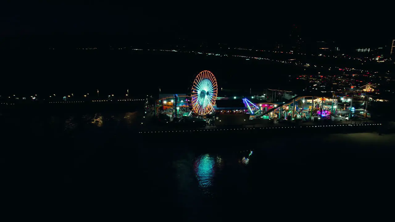 Night orbital drone shot of full santa monica pier lit up