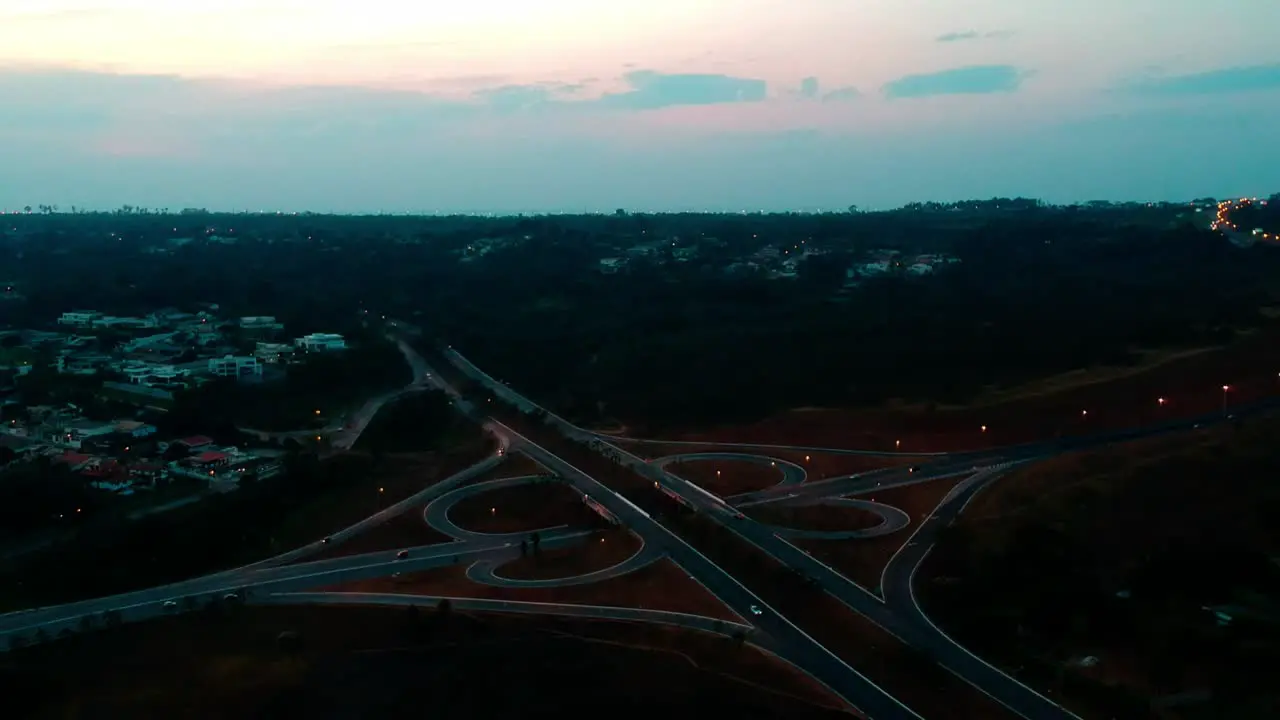 Outdoor stationary drone footage at dusk of a cloverleaf traffic pattern in Brasilia Brazil with vehicles traveling home from work