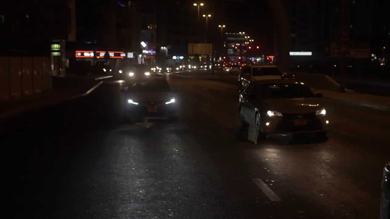 Busy traffic driving in downtown Dubai at night time in the United Arab Emirates in slow motion