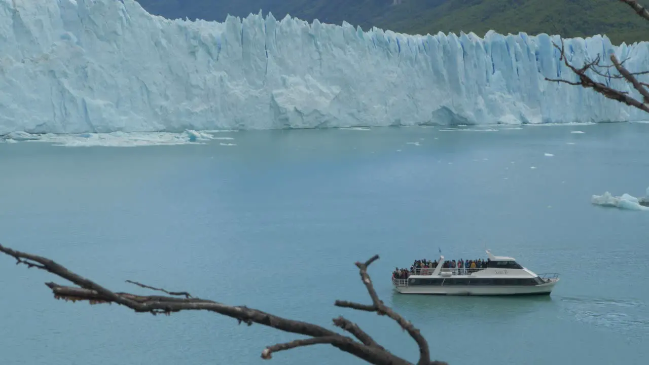 A tourist boat sails alongside a massive glacier in Patagonia