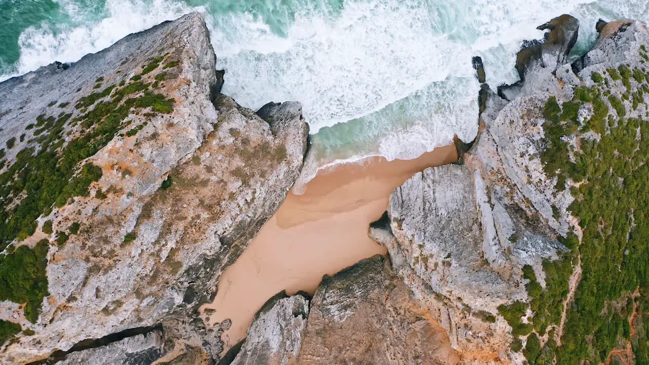 Tropical beach top view breaking waves on exotic rocky beach