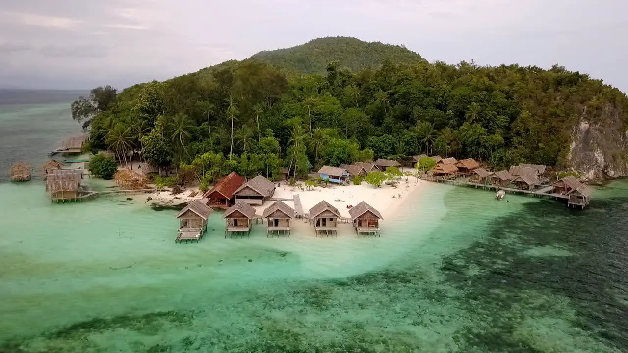 Resort with overwater bungalows in the Raja Ampat island chain in Indonesia  Aerial circle around shot