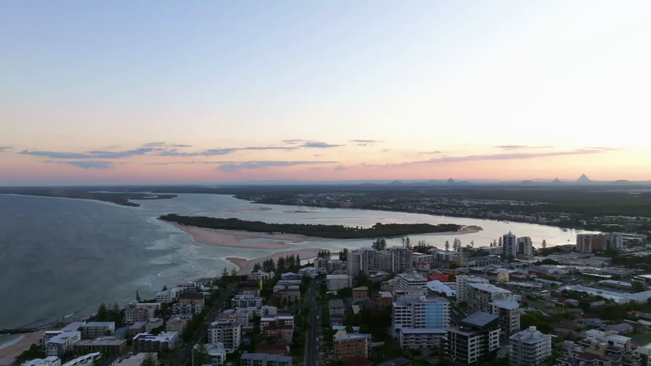 Drone Flyover Sunshine Coast Coastal Town At Sunset With Ocean Views And Pink Sky Caloundra Australia 4K