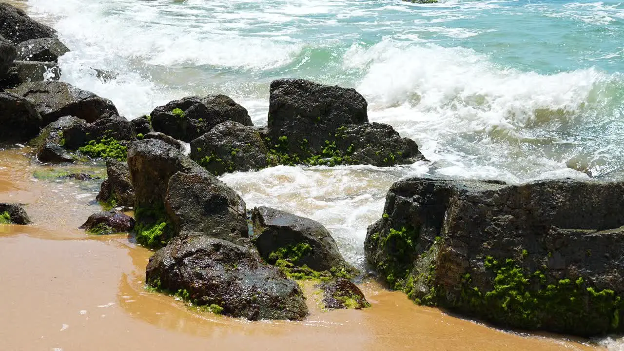 Ocean waves hit the rocky shore on the beach