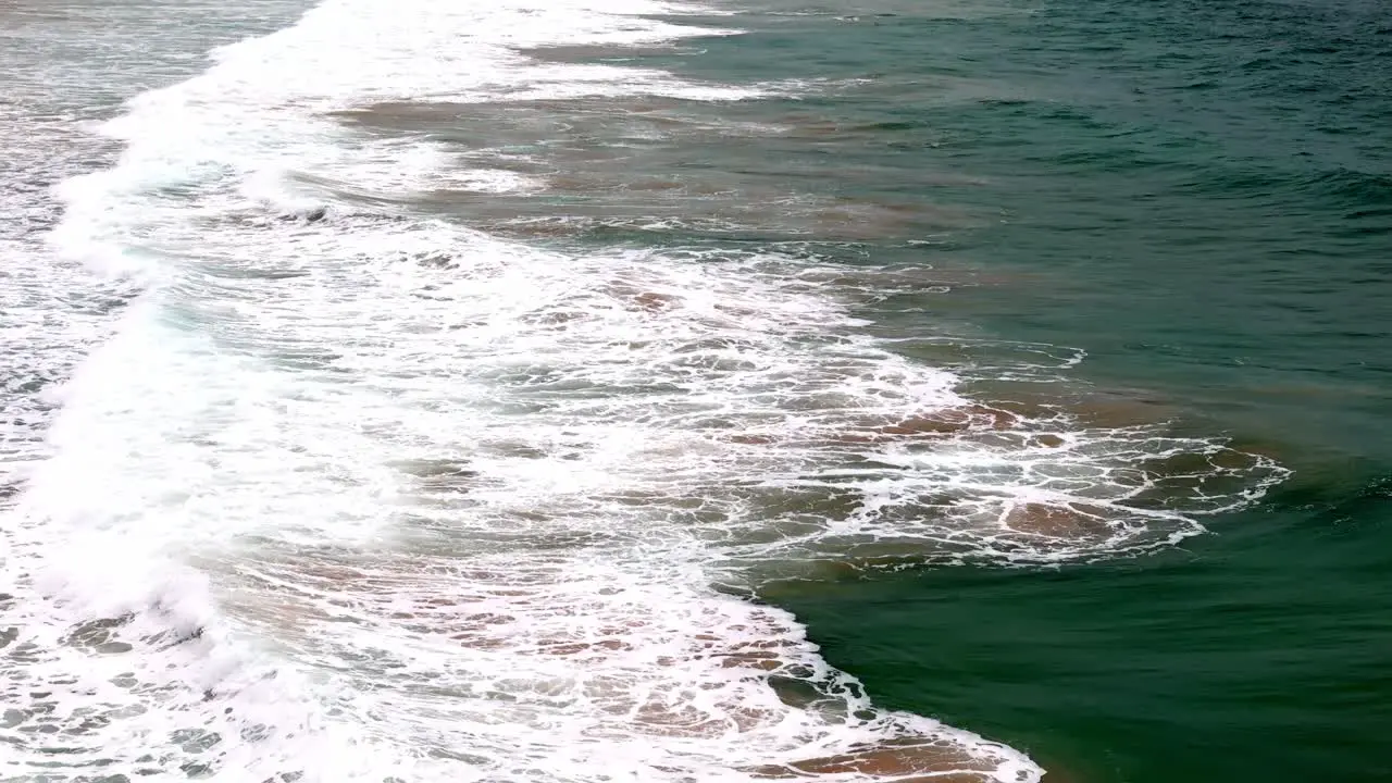 Evening tide rolling in on a sandy beach The play of sunset light on ocean waves