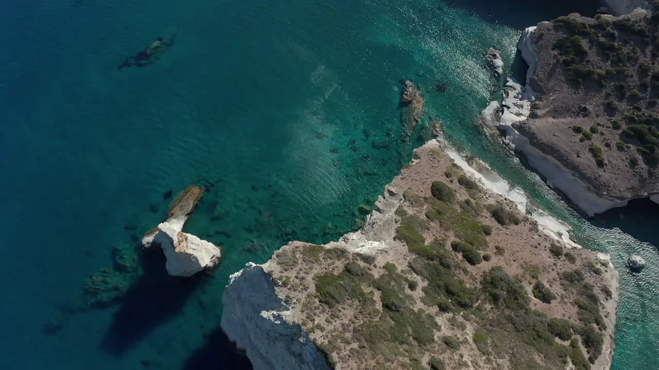 Aerial Wide Establishing Shot of Tropical Bay in Greece with White Rocks and Boats in the Ocean