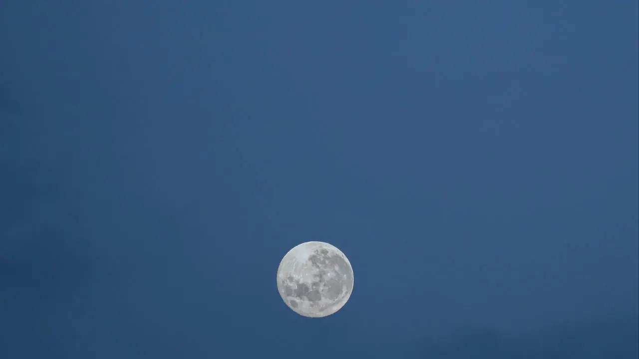 Timelapse of full moon crossing frame on a cloudy night