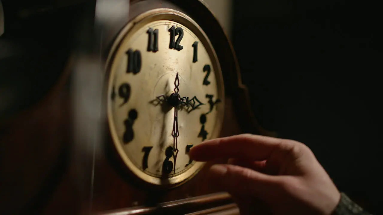 Hand changes time on an old mechanical clock