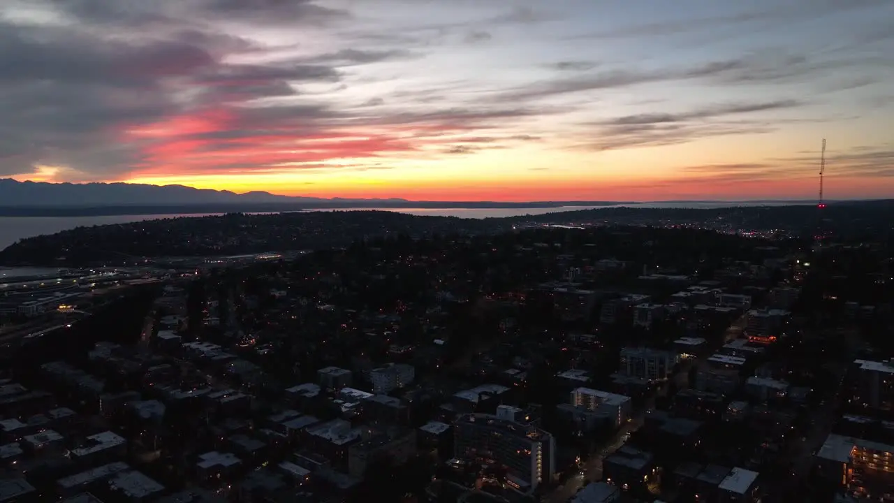 Lowering aerial shot of the sun setting over Seattle's Queen Anne neighborhood