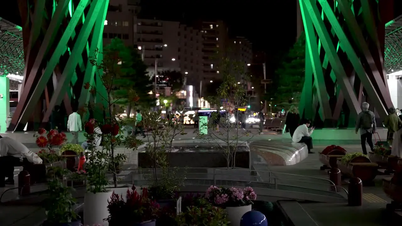 View Of Seating Area Beside Small Pond Feature Near The Tsuzumi Gate at JR Kanazawa Station East At Night