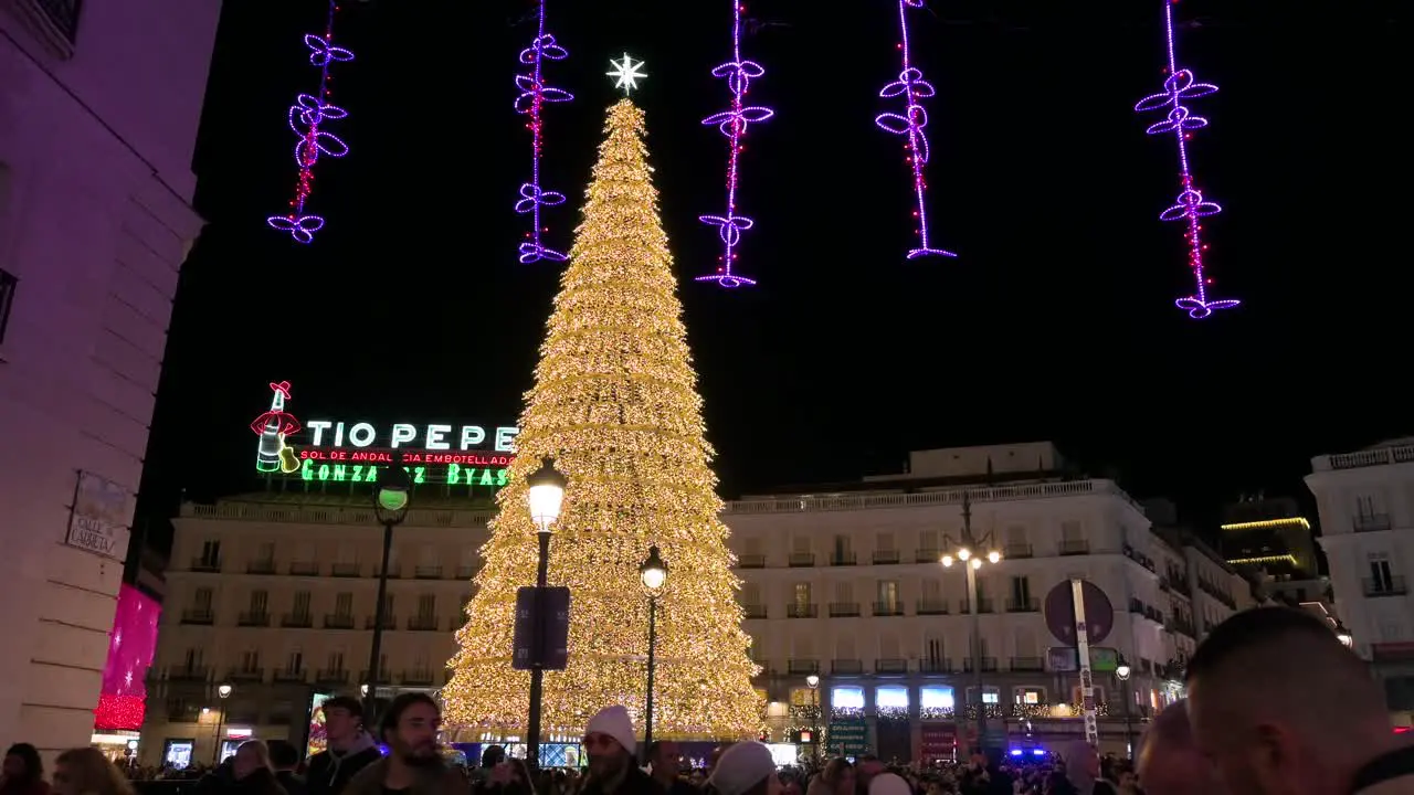 Illuminated Christmas tree installation decorated with gold LED lights during the Christmas season at Puerta del Sol Square in Madrid