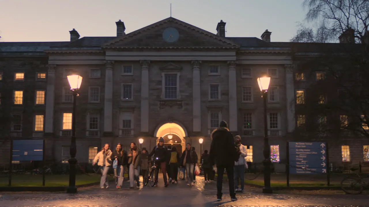 Students walking in the late afternoon at the entrance to Trinity College in Dublin Ireland