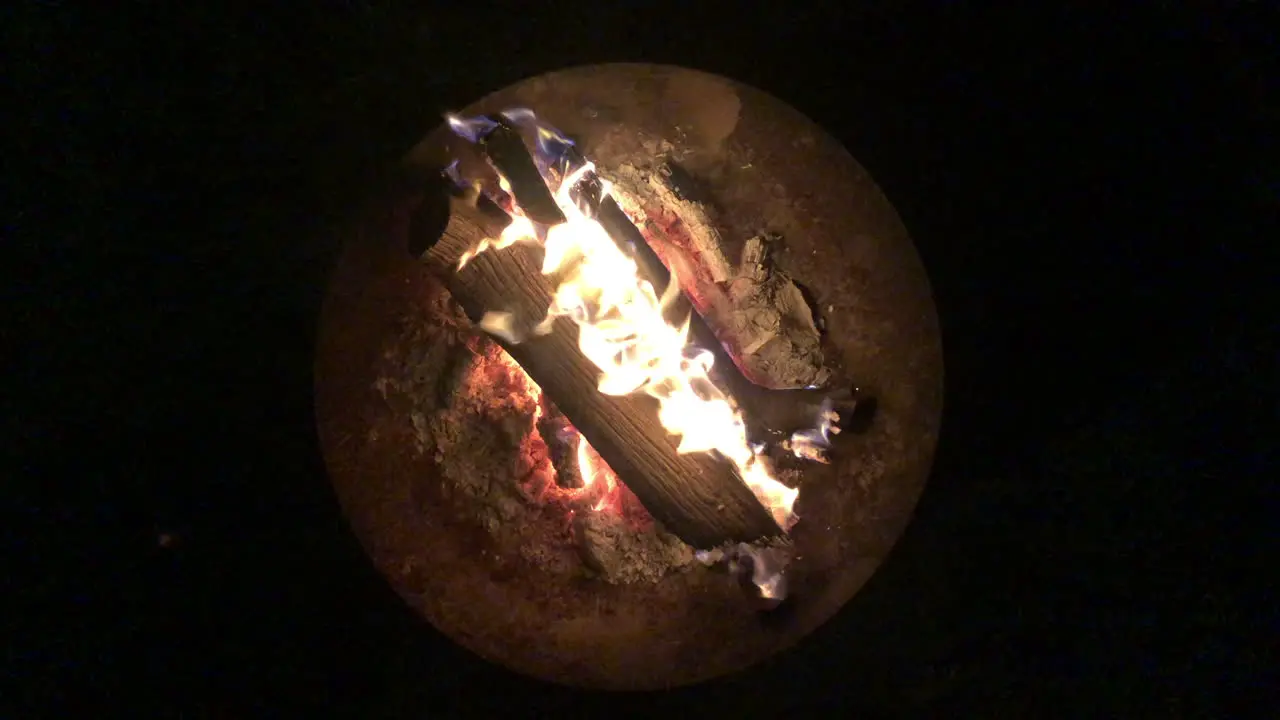 Top down view of a fire burning inside a fire bow shot on a pitch black night