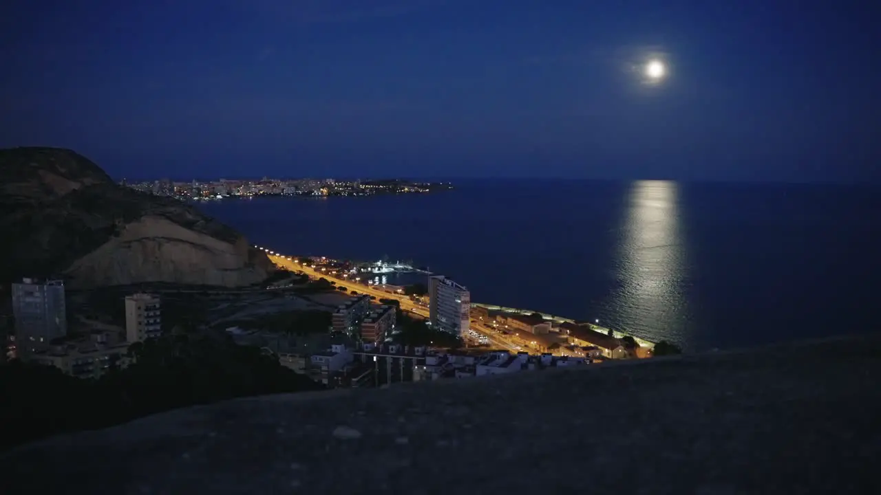 Alicante's coast at night seen from the top of the Castle Santa Barbara with moon Spain