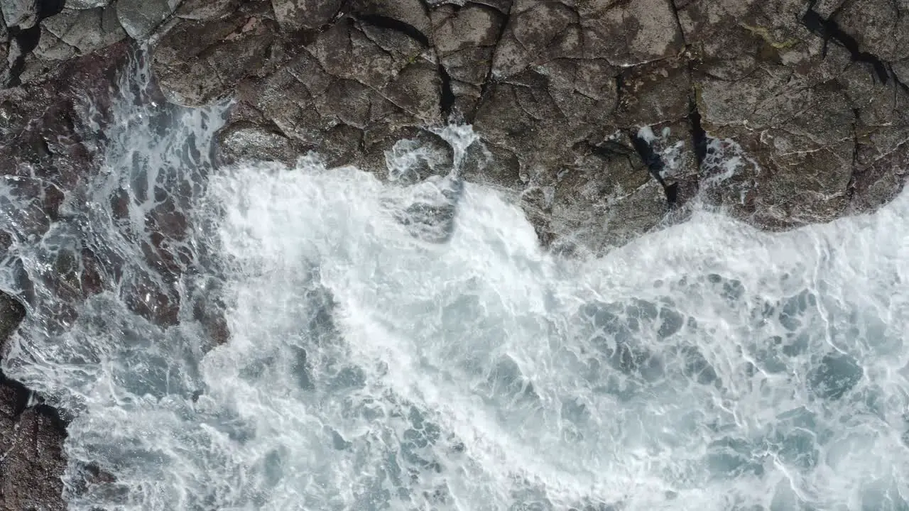 Top shot of a drone waves splashing on the coast of an ocean