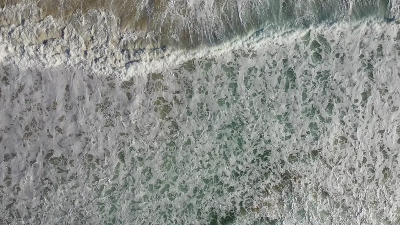 Overhead aerial shot looking straight down at crashing waves and surf in South Africa